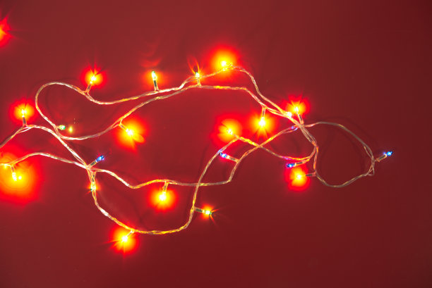 装饰LED灯泡与各种颜色和闪光在红色的背景。图片下载