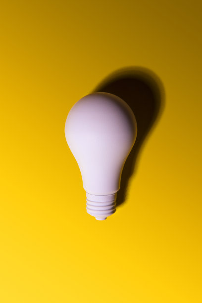 黄色背景上喷着白色灯泡图片下载