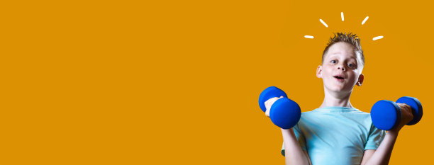 一个穿着亮t恤黄色背景上有哑铃的男孩图片下载