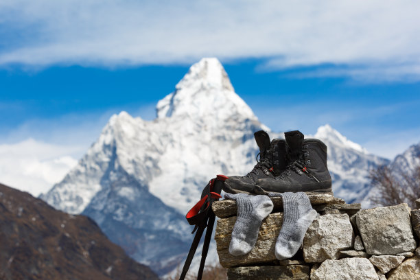 珠峰登山大本营。在阳光下晒的登山靴和袜子放在一块石头上。阿玛达布兰山是模糊的。尼泊尔。图片下载