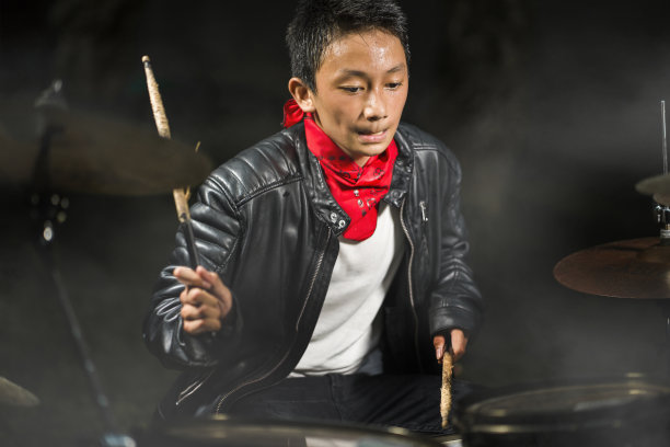 年轻酷和才华横溢的青少年音乐家打鼓在他14岁的皮夹克和头巾摇滚乐队风格练习和表演歌曲在青少年音乐爱好概念图片下载