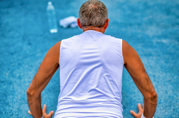 生命中的一天。运动是我们的生命。穿着运动服做日常锻炼的男人。在地上做俯卧撑。图片下载