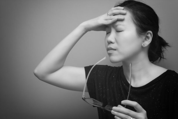 亚洲妇女抱着她的头，患有强烈的头痛和发烧，视力差，远视，近视。黑白色调图片下载