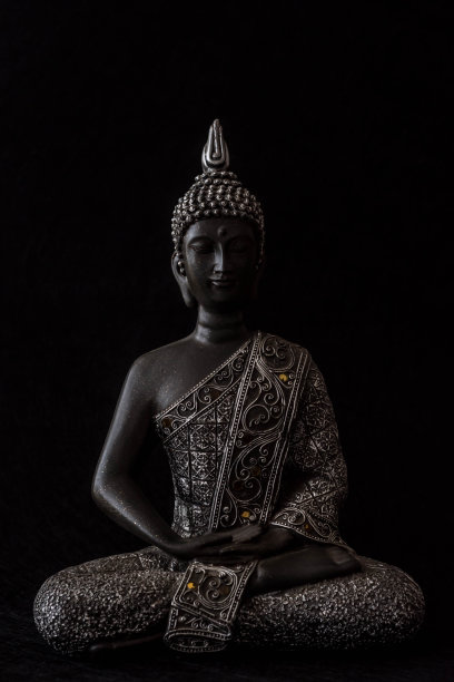 黑色背景上的蜡烛和装饰品佛像图片下载