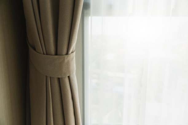 柔和的棕色窗帘与晨光从窗户卧室的背景图片下载