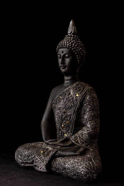 黑色背景上的蜡烛和装饰品佛像图片下载