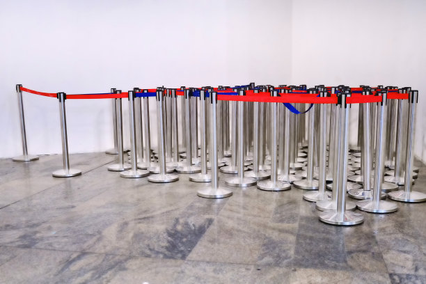 机场的监控录像。红蓝胶带护栏排成一行，让人们在机场候机楼排队服务图片下载