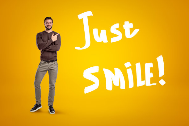 快乐的男人穿着休闲衣服，黄色背景上写着“只要微笑!图片下载