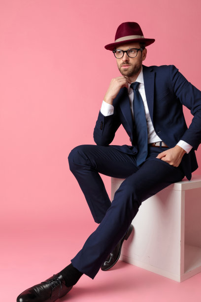 商人坐在那里，双手休息，整理着衣领，沉思着图片下载