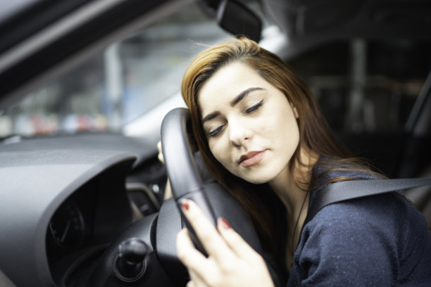 精疲力竭的女人睡在方向盘上图片下载