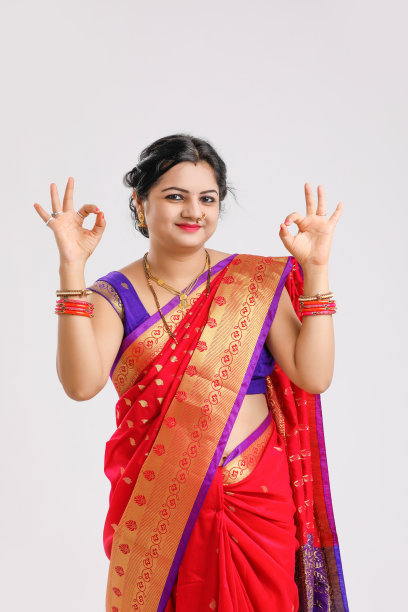 年轻的印度妇女穿着纱丽，在白色的背景下做OK的标志图片下载