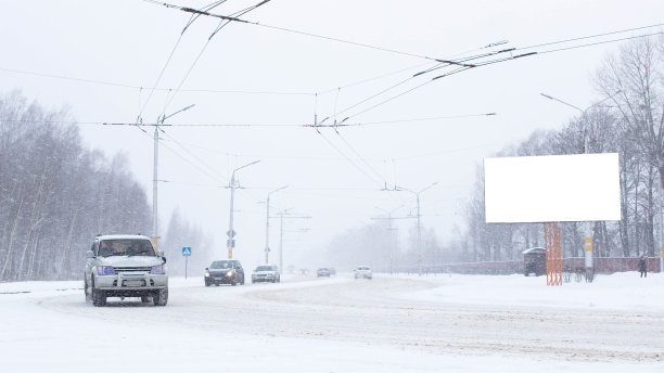 在城市的道路上有汽车在冬天，雪很多。广告牌，放置文字，拷贝空间图片下载