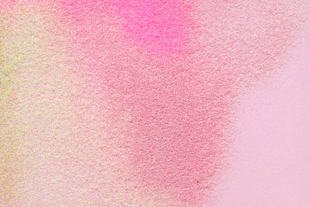 许多多色的亮片散布在粉红色的背景上。图片下载