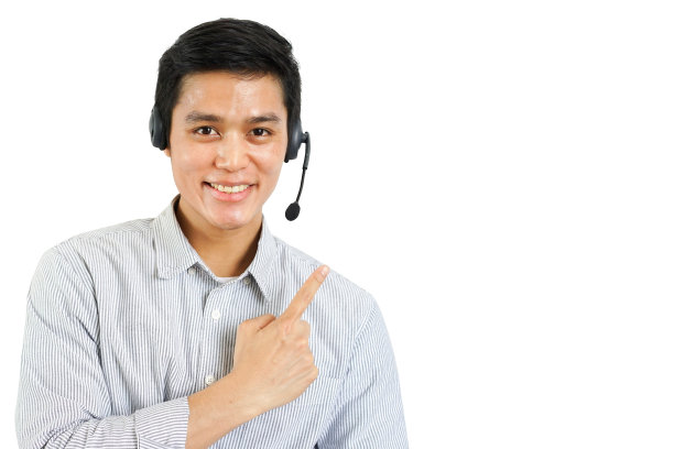 近距离呼叫中心员工年轻的亚洲男子戴着耳机设备和指着的手孤立在白色背景上的商务电话营销和帮助台设计概念图片下载