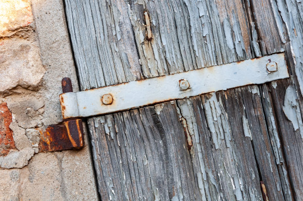乡村住宅的窗户细节，在砖墙和古老的石头上有开裂的油漆和生锈的铰链。图片下载
