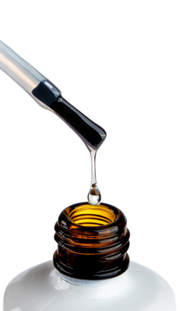 漆滴在笔尖。恶性液滴和白色玻璃瓶。指甲护理技术，哑光液体。美丽透明的斑点孤立在白色图片下载