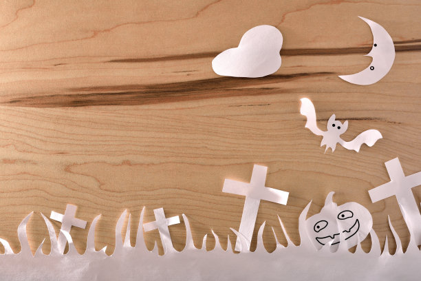 用白纸在木桌上剪出的万圣节工艺品图片下载