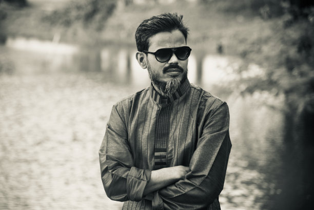 一个戴着墨镜的年轻人站在一个地方图片下载