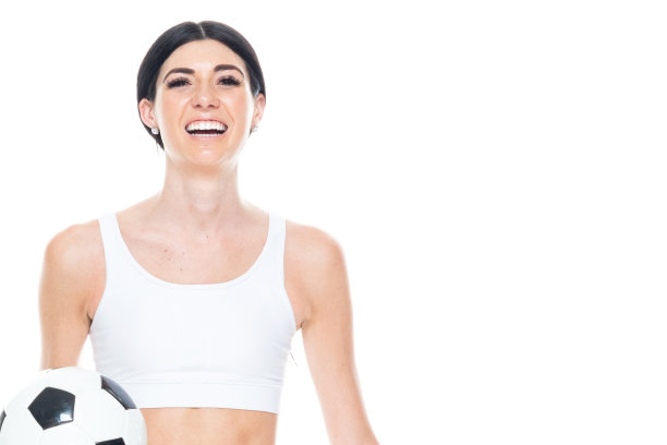 一个人/正面视图/腰部以上的20-29岁的成年人美丽/高个子/长发高加索年轻女性/女足球运动员在白色背景前穿着运动胸罩/弹力纤维/打底裤谁是微笑/快乐/愉快图片下载