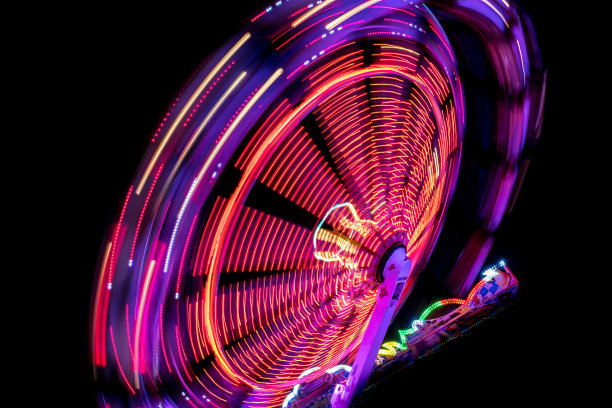 在一个有趣的公园里，从快速旋转木马上走出来的彩色灯光图片下载