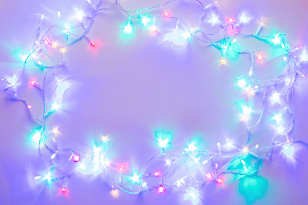 闪亮的节日多色圣诞灯框架与复制空间，发光的紫色和薄荷色花环图片下载