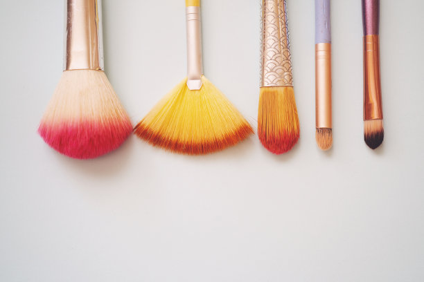 旧的腮红刷与腮红上化妆，选择性聚焦蓝色背景与文本空间。图片下载