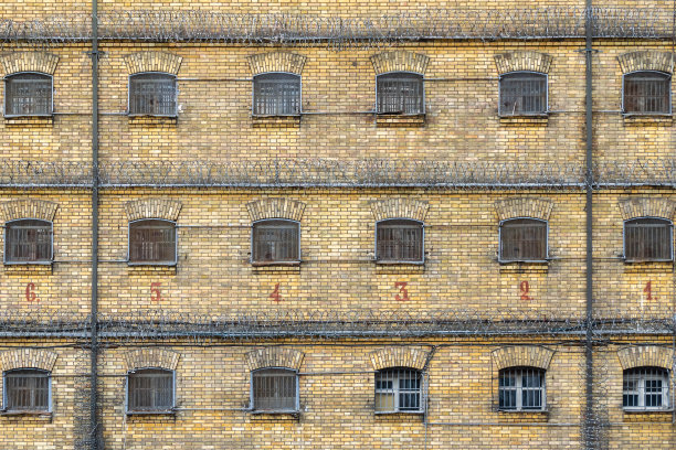 废弃的监狱砖墙和带栅栏的牢房窗户图片下载