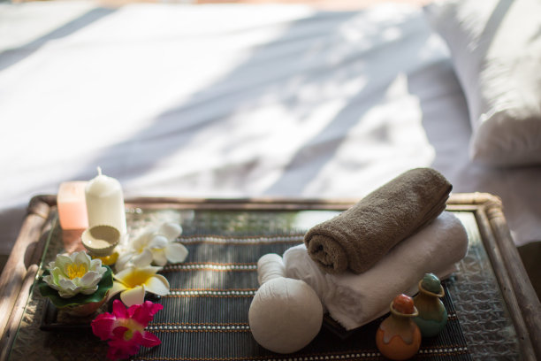在白色水疗按摩床上使用蜡烛，按摩油和草药按摩方块图片下载