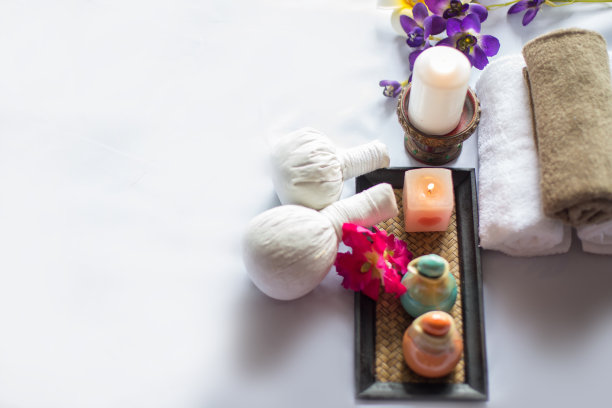 在白色水疗按摩床上使用蜡烛，按摩油和草药按摩方块图片下载