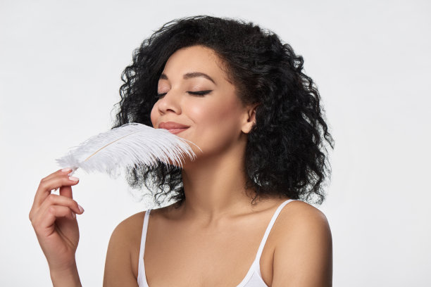 美丽的混血儿女人拿着白色的鸵鸟羽毛图片下载