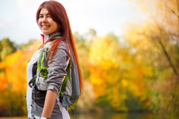 照片微笑的女人与背包和自行车头盔图片下载