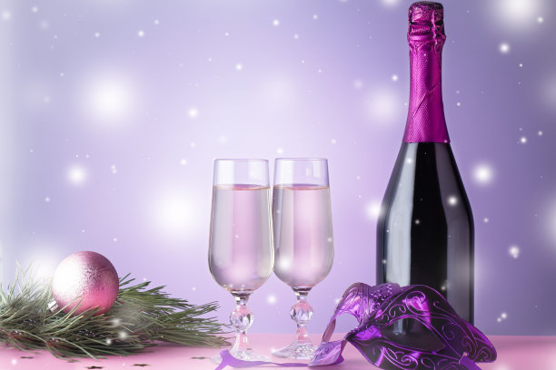 圣诞贺卡配香槟杯、酒瓶、嘉年华面具、圣诞装饰品、粉红色冷杉树枝。图片下载