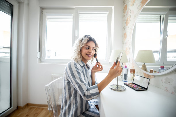 年轻女子在镜子前化妆图片下载