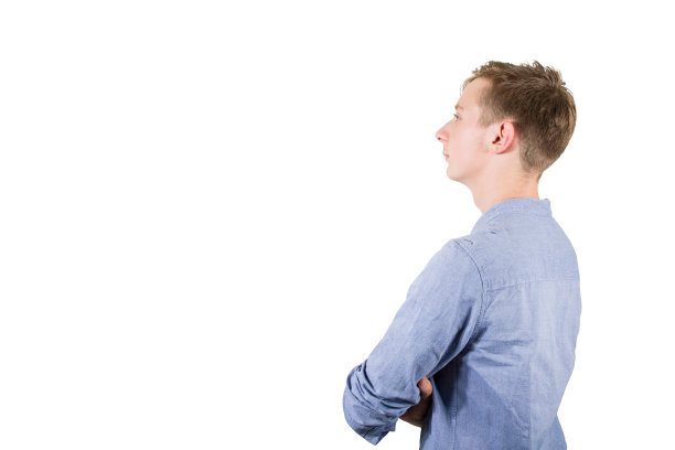 侧面的自信，严肃的十几岁的男孩保持双手交叉，看着一边孤立的白色背景。图片下载