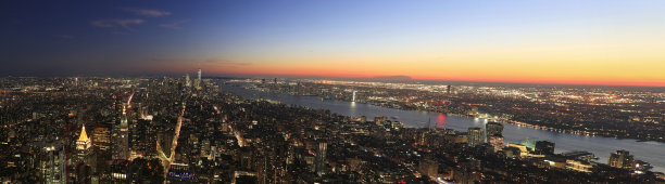 全景鸟瞰图的纽约市，下曼哈顿天际线照亮在日落包括一个世界贸易中心和自由岛图片下载