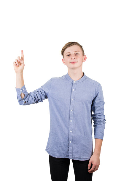 不经意的少年指着他的食指孤立的白色背景。图片下载