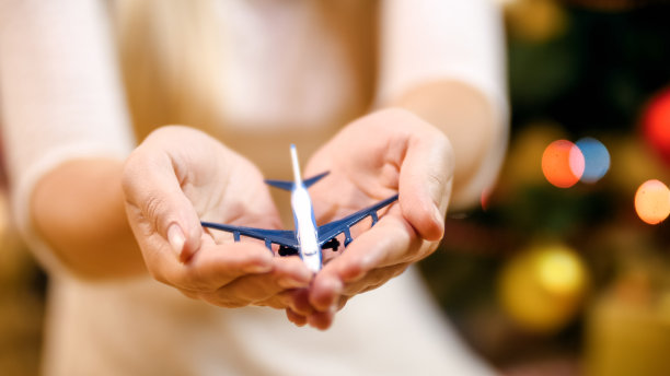 年轻女子手持小飞机的特写图像。寒假旅游的概念图片下载