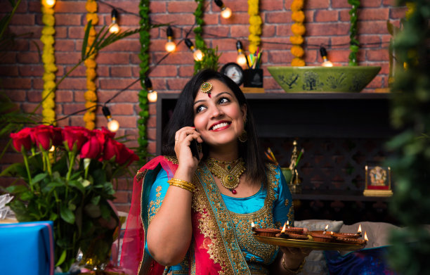 印度女孩拿着传统服饰的排灯节，点击自拍图片或通过智能手机说话。图片下载