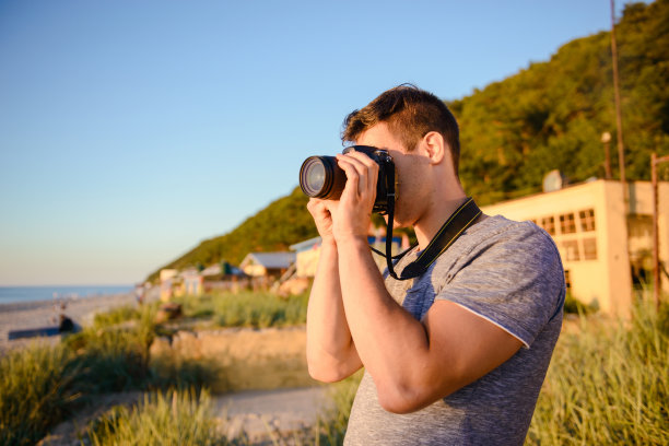 海滩上年轻摄影师的剪影图片下载