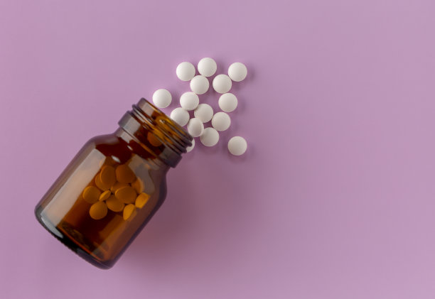 白色的圆片散落在一瓶药的周围图片下载