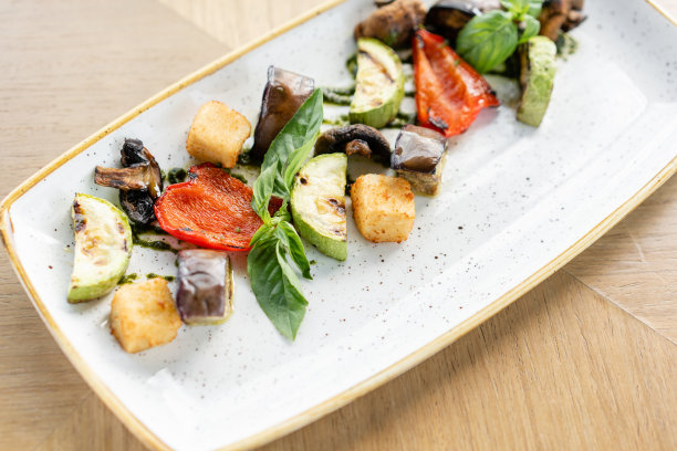 烤蔬菜配羊乳酪。放在盘子里，放在桌子上。餐厅烧烤菜单，一系列不同菜品的照片图片下载