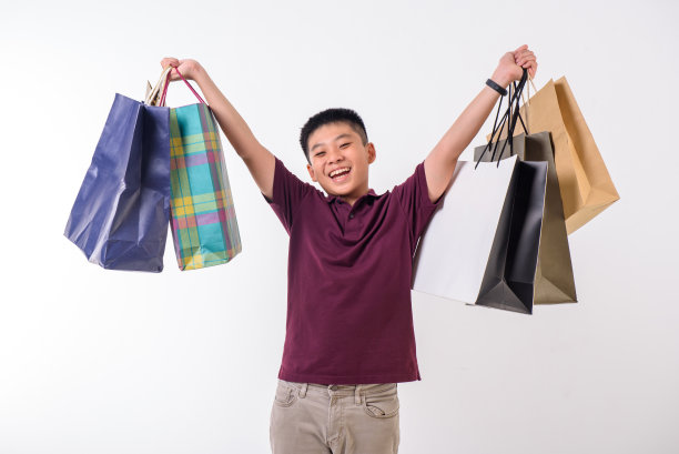 年轻的亚洲男孩提着购物袋。节日的准备图片下载