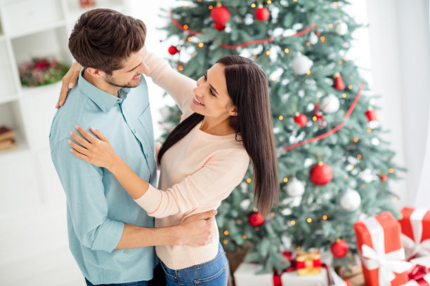 上面的高角度照片两个迷人的浪漫的人跳舞享受圣诞时间圣诞节假期在房子与常青树和礼物盒室内图片下载