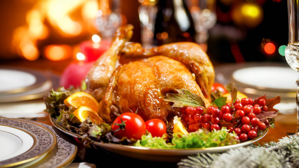 在客厅里燃烧着壁炉的家庭餐桌上美味的烤鸡的特写图像图片下载