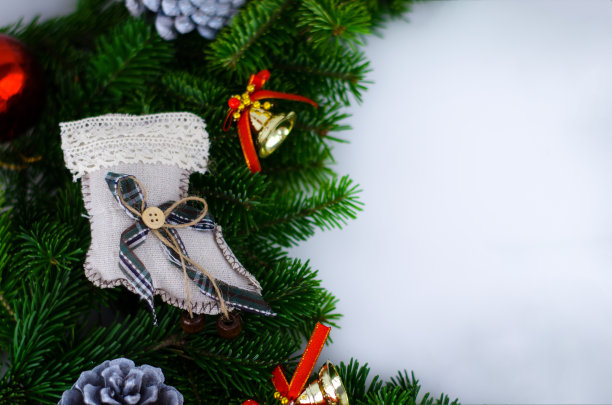 圣诞花环用新年玩具来装饰——圣诞袜、装饰松果、玻璃红球、铃铛。图片下载