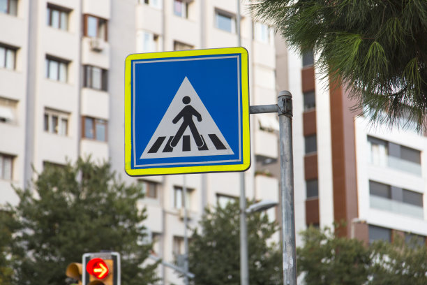 城市街道上的行人过街标志，背景为建筑物。城市交通和交通灯。交通、城市生活和交通标志概念。水平背景的特写镜头。图片下载