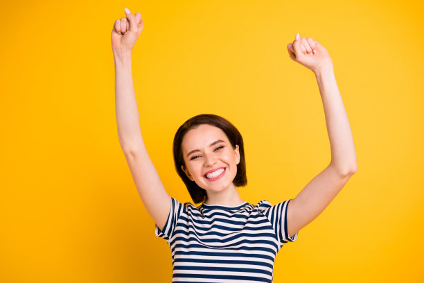 令人惊异的女士举起手庆祝最喜欢的足球队的冠军地位的照片穿白色蓝色条纹t恤孤立的黄色背景图片下载