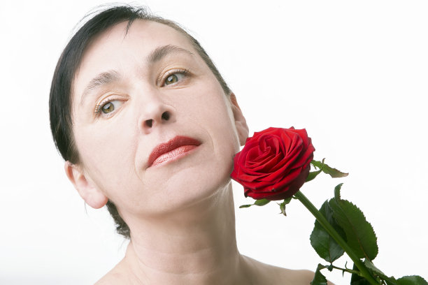 一个中年妇女的脸。一个美丽的四十岁女人的肖像与玫瑰图片下载