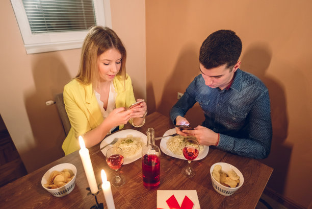 情侣在浪漫晚餐时打电话图片下载