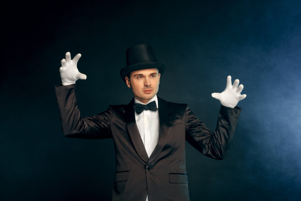 专业的职业。表演者戴着西装手套和帽子孤立地站在墙上，营造出神秘的气氛图片下载